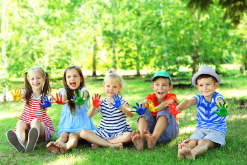 Happy active children with bright colored palms in park