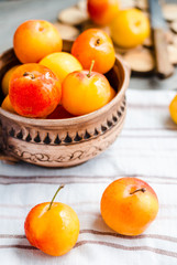 raw plums in pottery on wooden table, rustic, healthy food,