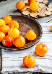yellow plums in pottery on wooden table, rustic, healthy food, r