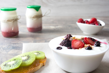 Natural yogurt with fresh berries, milk and toast with fruit and cereals