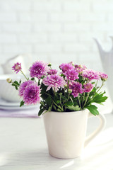 Fototapeta na wymiar Beautiful flowers in decorative vase on table, on light background