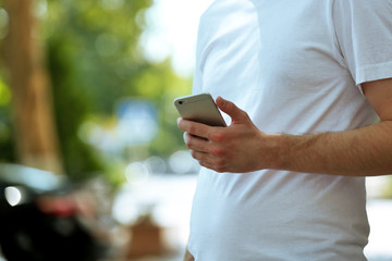 Man holding smart mobile phone outdoors