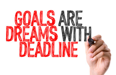 Hand with marker writing: Goals Are Dreams With Deadline