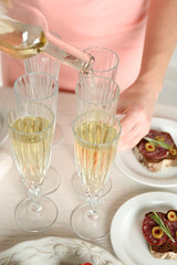 Woman pouring wine into glass, close up