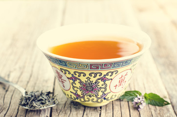 Teapot on a wooden background with flower and spoon 