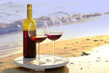 Wine bottle and glasses on the seashore