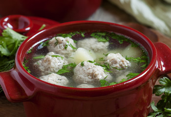 Soup with meatballs in red pots, selective focus