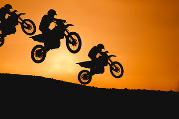 Obraz na płótnie Canvas motorcycle silhouette are jumping on sunset