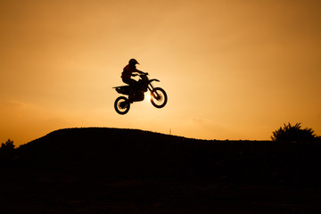 motorcycle silhouette are jumping on sunset