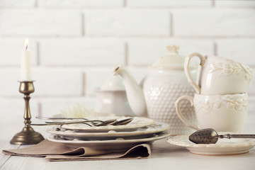 Clean dishes on table on brick wall background