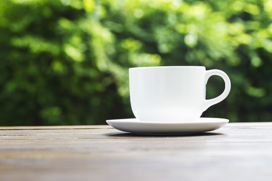 White coffee cup on green bokeh background