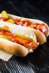 Hot dogs on a black wooden table