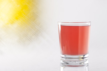 glass of grapefruit juice on an abstract background