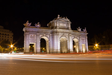 Obraz premium Puerta de Alcalá. / The Puerta de Alcalá is one of five former royal doors giving access to the city of Madrid (Spain). It is located in the center of the roundabout at the Plaza de la Independencia.