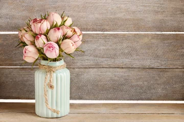 Fototapeten Bouquet of pink roses in turquoise ceramic vase © agneskantaruk