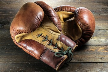 alte Boxhandschuhe auf rustikalem Holzhintergrund