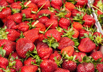 Strawberry heap close up at market on a sunny day
