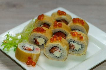 Close-up of a white plate with sushi set - Russian pancakes with