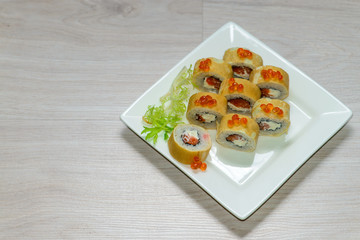 Close-up of a white plate with sushi set - Russian pancakes with