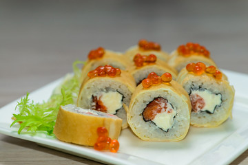 Close-up of a white plate with sushi set - Russian pancakes with