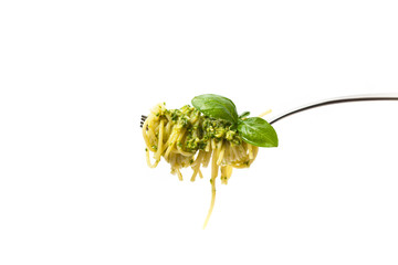 Pasta with pesto on a fork on white. Selective focus.
