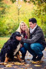 Naklejka na ściany i meble Paar mit Hund genießt den Herbst in der Natur
