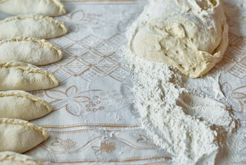 Kitchen, cooking pies with dough on the table