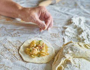 Kitchen, cooking pies with dough on the table
