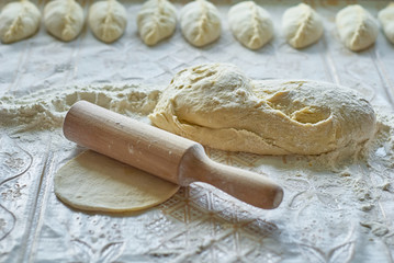 Kitchen, cooking pies with dough on the table
