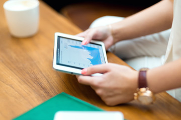 Young, beautiful girl in a white suit, sitting in a cafe and wor