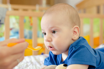 baby boy eating on the bed