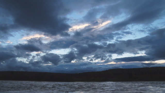 Fast Clouds and the River/ Dark clouds move quickly over a noisy river in the evening. The river in the autumn forest. Time lapse
