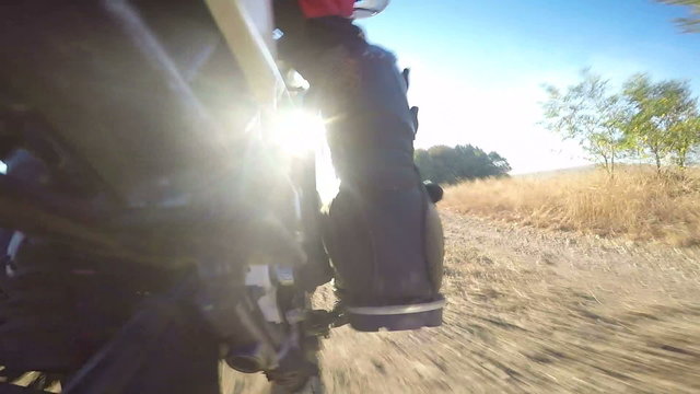  Enduro racer riding bike on dirt track rear wheel point of view