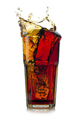 Splashing cola in glass. Isolated on white background