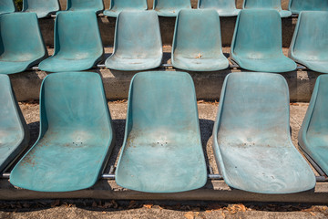 Abandoned empty plastic chairs at the Arena facing the sun