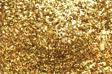 Holiday yellow glitter, gold sand and dust texture. Golden sparkling background. Orange brown metallic surface. 
