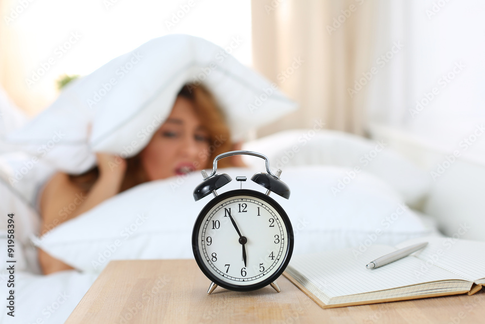 Wall mural Young beautiful woman hates waking up early in the morning