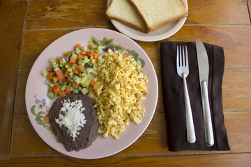 Huevo revuelto con frijol, pan y verduras