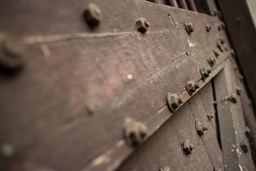 Close up of Heavy wooden door of a temple in Asia studded with b