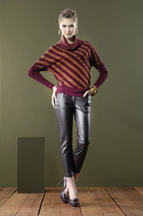 Full length young woman posing with cube on wooden floor