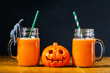 Halloween pumpkin with carrot juice in masons jars