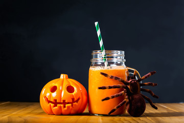 Halloween pumpkin with carrot juice in masons jar