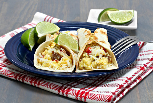 Two breakfast tacos with chorizo, eggs and peppers.