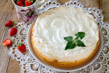 Meringue cake with strawberries on a wooden table