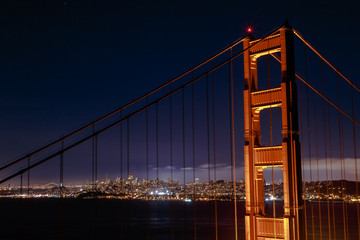 Fototapeta na wymiar The glowing city of San Francisco through the Golden Gate Bridge