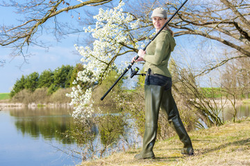 woman fishing at pond in spring