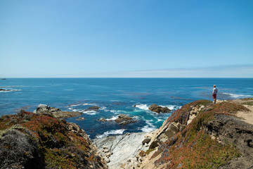 Man standing at contemplating life looking at beautiful coastal view along the Pacific Coast Highway Route 1, California, United States