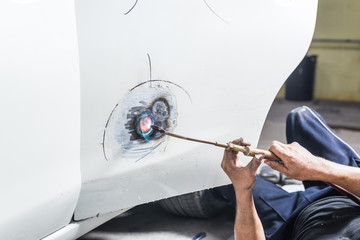 Car paint repair series : Worker repairs white car paint
