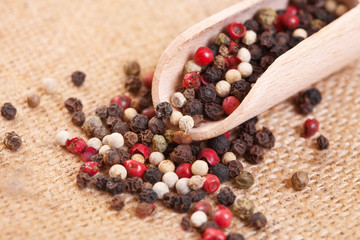 Red, white and black pepper in a spoon