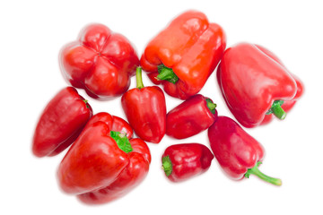 Several red bell peppers different sizes on a light background